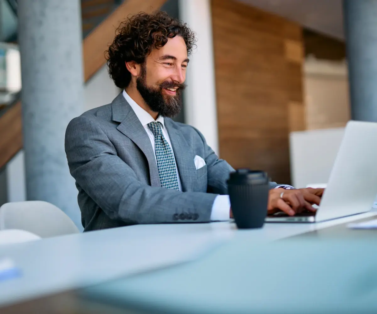 Man typing on a laptop happily