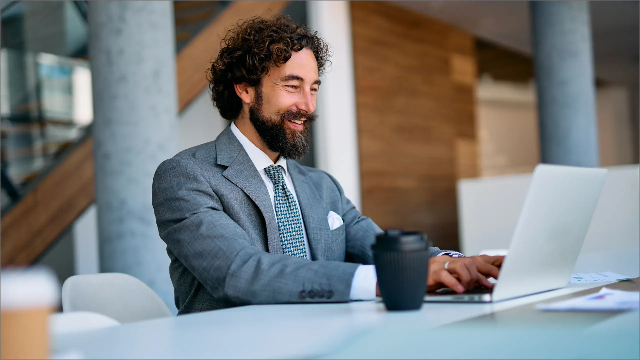 Man smiling looking at his laptop at work