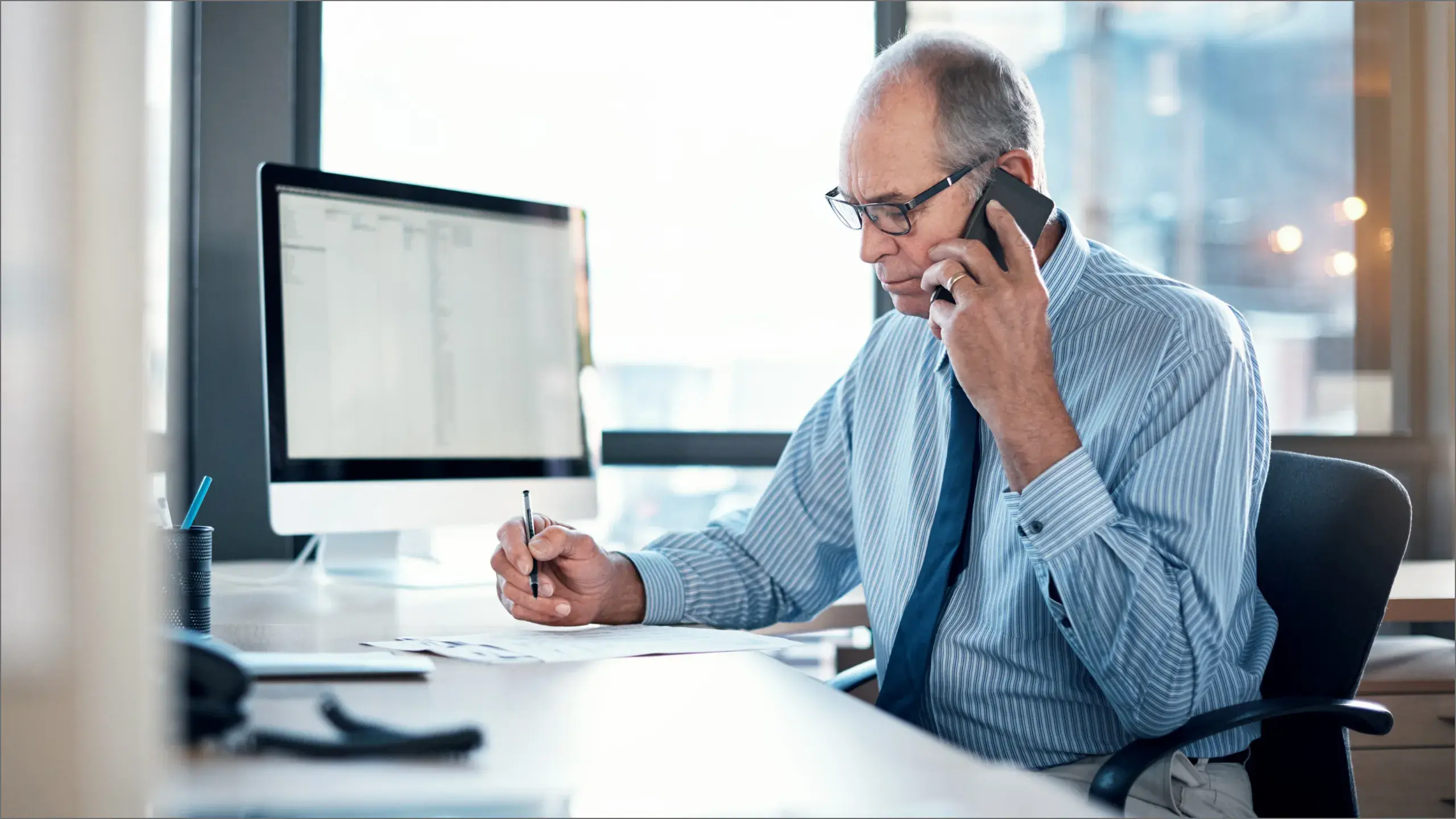 Man looking at document while on the phone